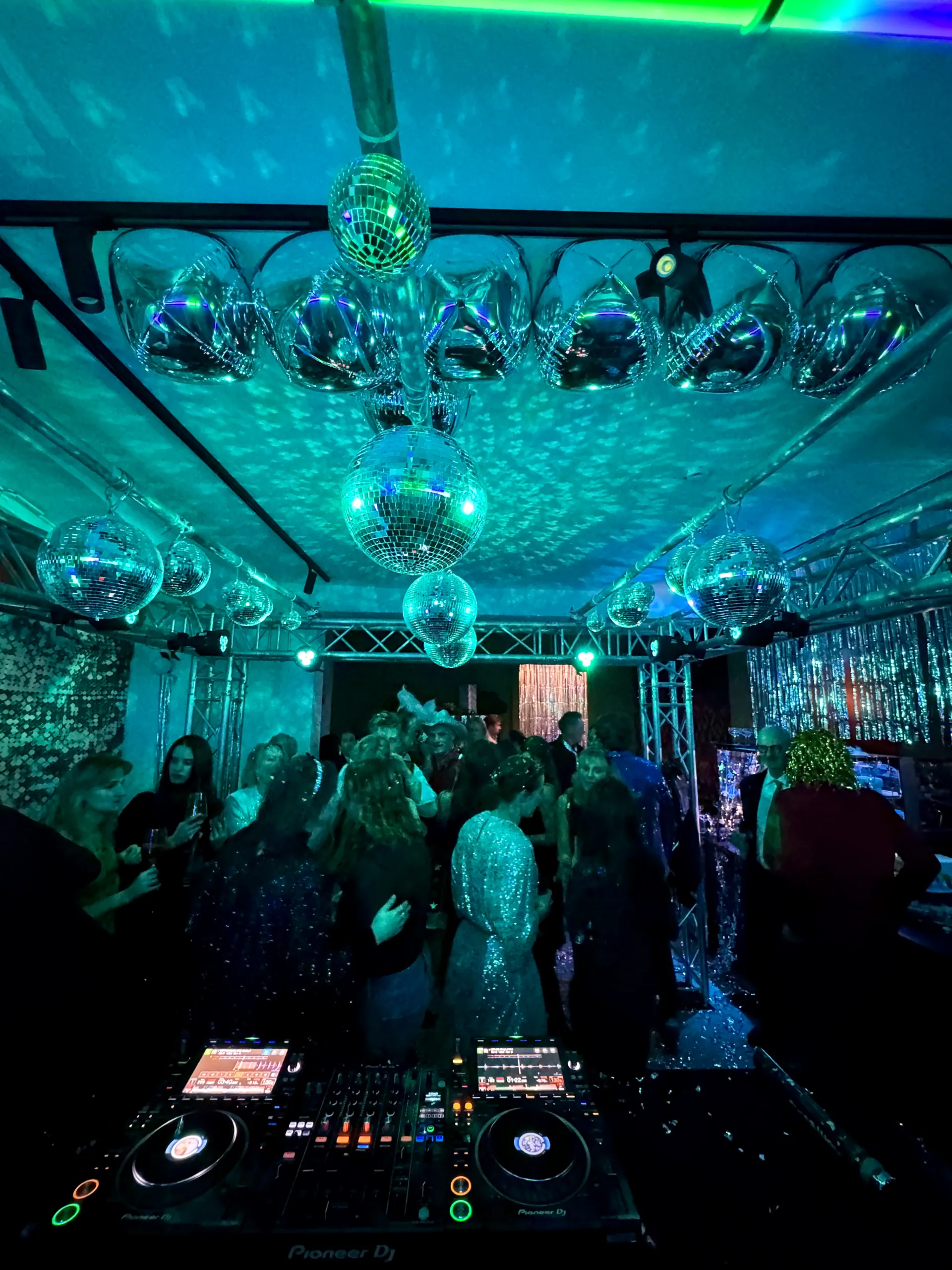 DJ-Setup mit Mischpult und Discokugeln in einem Club